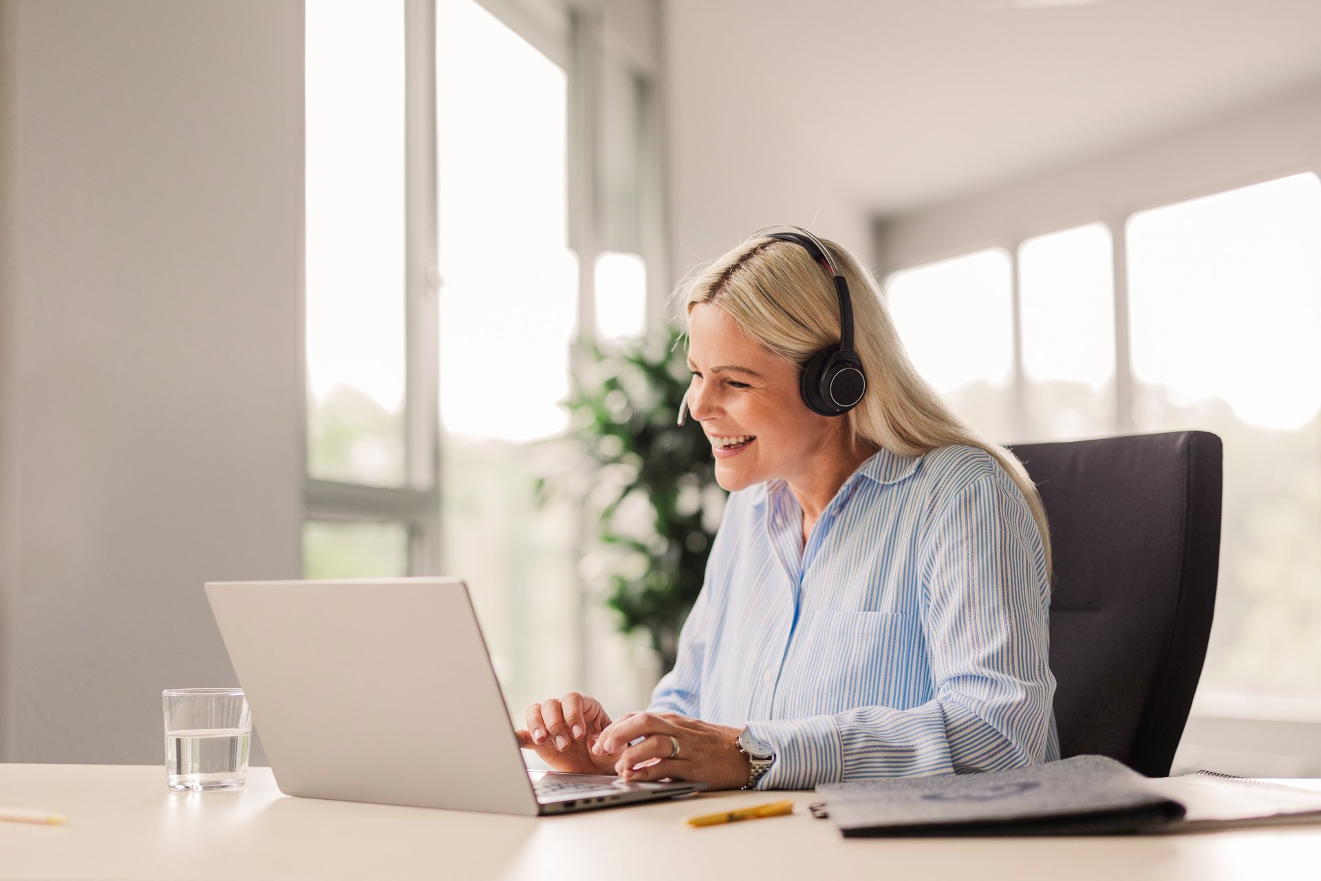 Eine Trusted Shops Mitarbeitern ist in einem Kundengespräch vor ihrem Laptop.